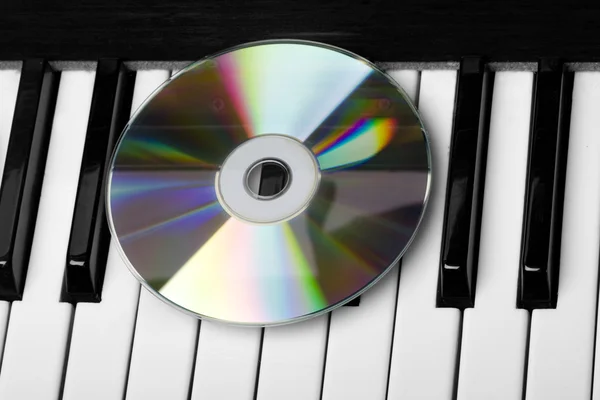Napęd CD, leżącego na klawiszach fortepianu — Zdjęcie stockowe