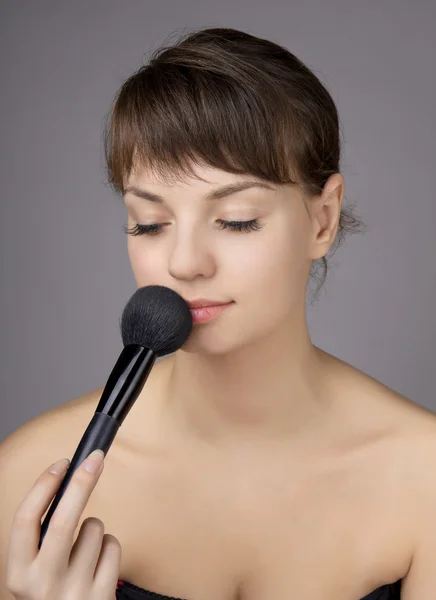 Beautiful girl who does make-up brush — Stock Photo, Image