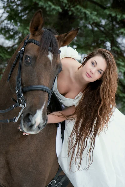 Flicka i en vit klänning på en häst — Stockfoto
