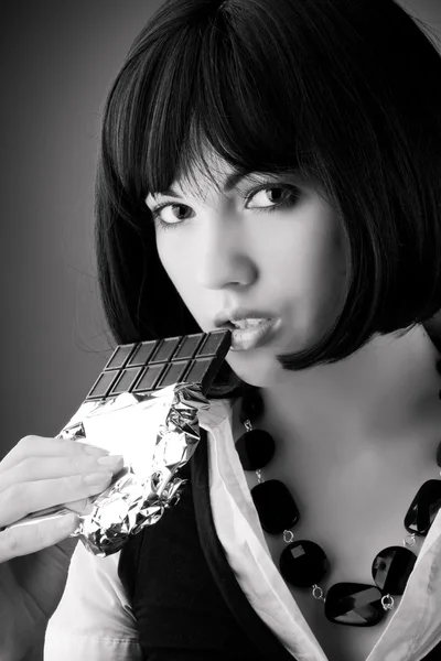 Mädchen, brünette, die Schokolade isst. — Stockfoto