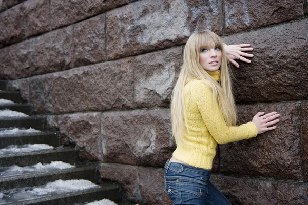 Modelo menina ao lado de uma parede de pedra e escadas — Fotografia de Stock