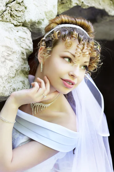 Lockige Braut vor dem Hintergrund der steinernen Ruinen — Stockfoto