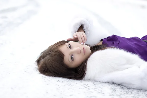 Девушка, которая лежит на снегу в платье — стоковое фото