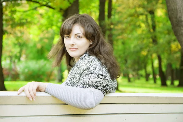 Dívka na lavičce v parku — Stock fotografie