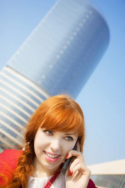 Meisje in een rode jurk, die is praten over de telefoon — Stockfoto