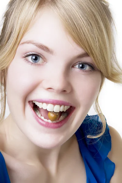 Blond tjej med muttern i tänderna — Stockfoto