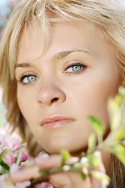 Vacker flicka i en blommande trädgård — Stockfoto