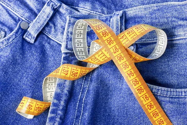 Ruban à mesurer sur fond de jeans — Photo