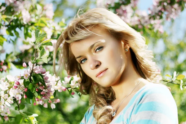Hermosa chica en un jardín floreciente — Foto de Stock
