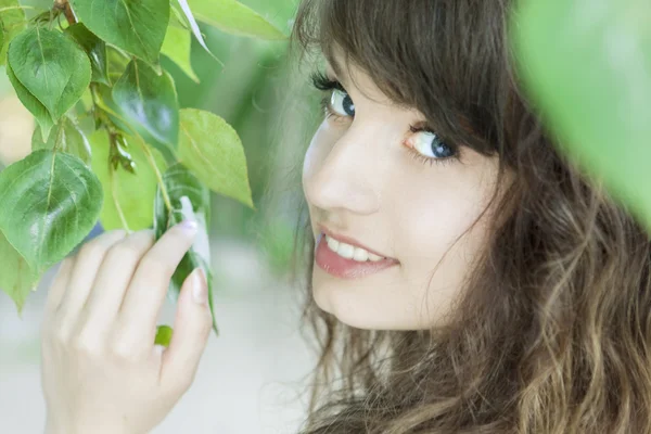 Girl with blue eyes in the foliage — Stock Photo, Image