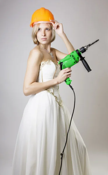 stock image Girl in evening dress with a drill