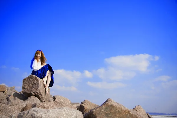Девушка-модель в синем платье на фоне голубого неба — стоковое фото