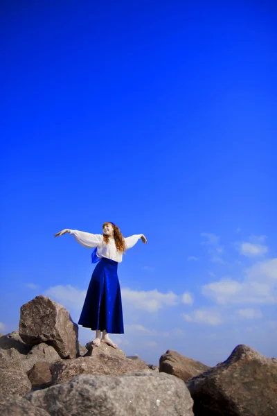 Meisje model in een blauwe jurk tegen een achtergrond van de blauwe hemel — Stockfoto