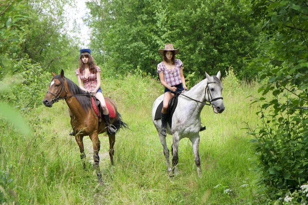 Meisjes rijden paarden in het park — Stockfoto