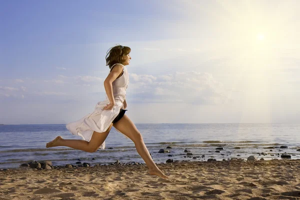 Menina pulando na praia — Fotografia de Stock