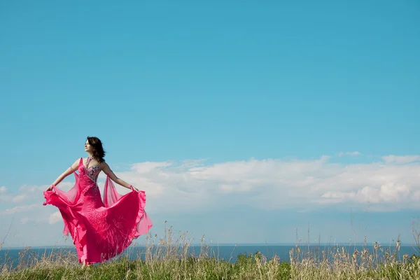 Fata în rochie roz pe fundalul cerului . — Fotografie, imagine de stoc