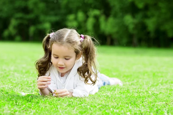 Kind liggen op het gras — Stockfoto