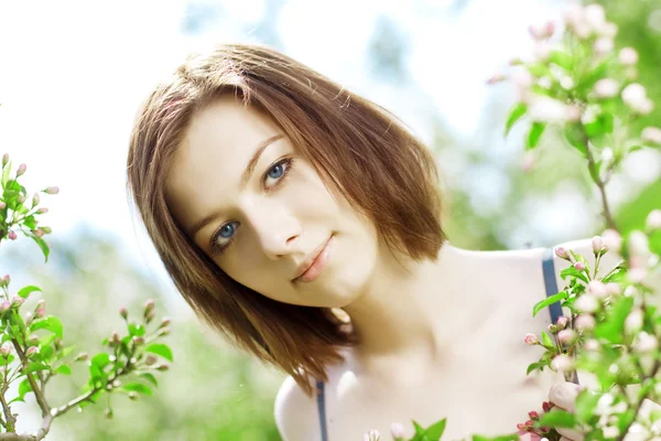 花の咲く木の中で美しい少女 — ストック写真