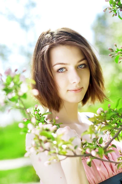Beautiful girl among the blooming trees — Stock Photo, Image