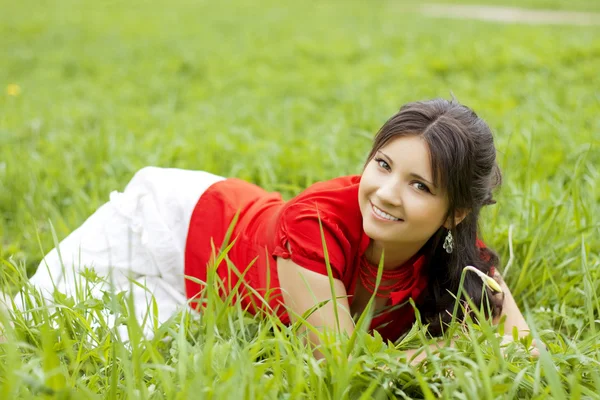 Schönes Mädchen auf dem Gras liegend — Stockfoto