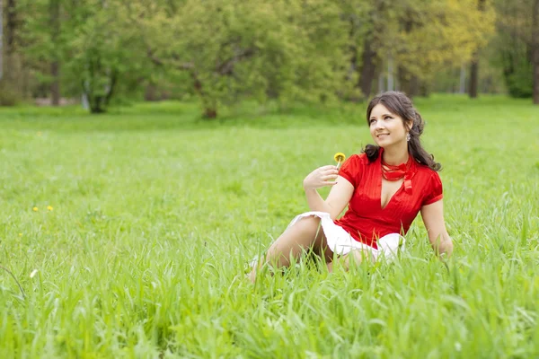 Piękna dziewczyna siedzi na trawie — Zdjęcie stockowe