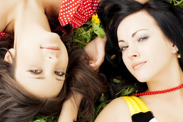Dwie piękne dziewczyny, leżąc na trawie. — Zdjęcie stockowe