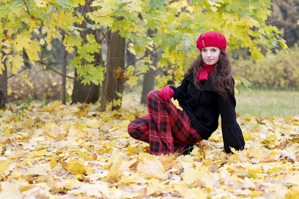 Žena v červené barvě v podzimním parku — Stock fotografie