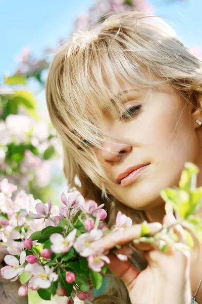 Bella ragazza in un giardino fiorito Foto Stock