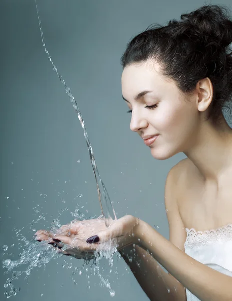 Flicka som häller vatten på händerna — Stockfoto