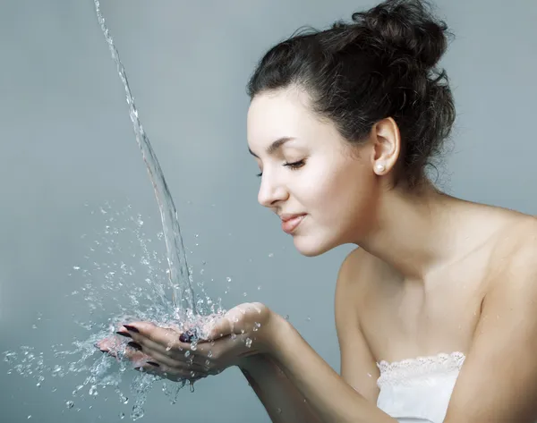 Meisje water op zijn handen giet — Stockfoto