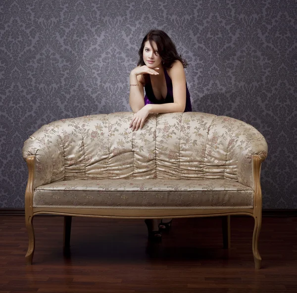 Glamouröses Mädchen auf der Couch — Stockfoto