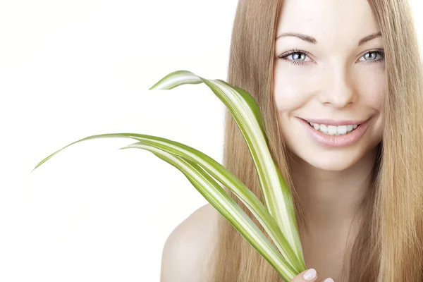 Vacker flicka med en grön växt i händerna — Stockfoto