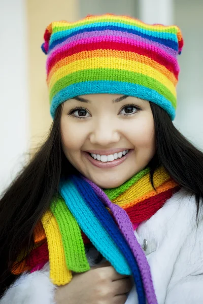 Menina em um cachecol e chapéu de cores do arco-íris — Fotografia de Stock