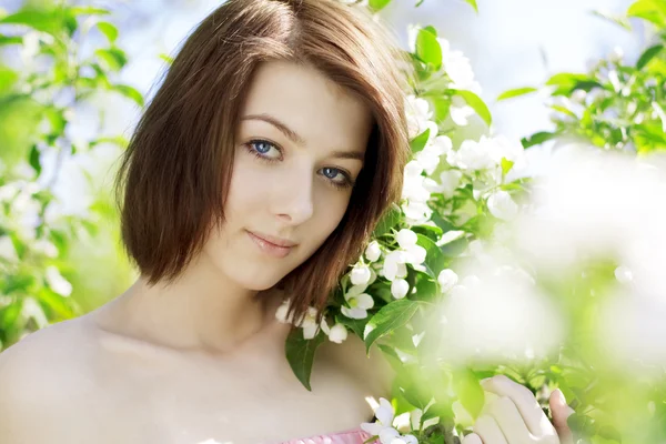 Девушка на фоне цветущих цветов — стоковое фото