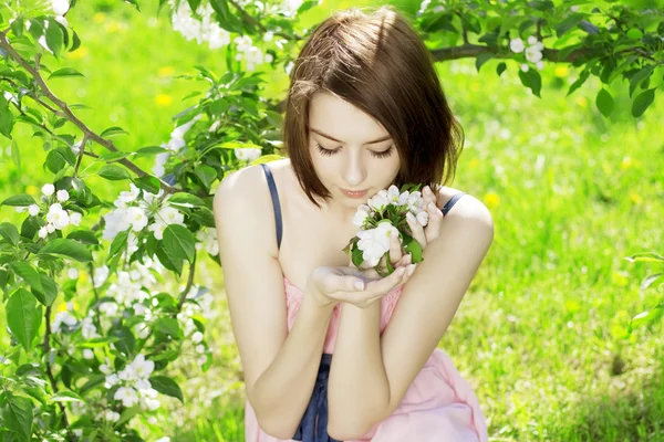 Menina em um fundo de flores floridas — Fotografia de Stock