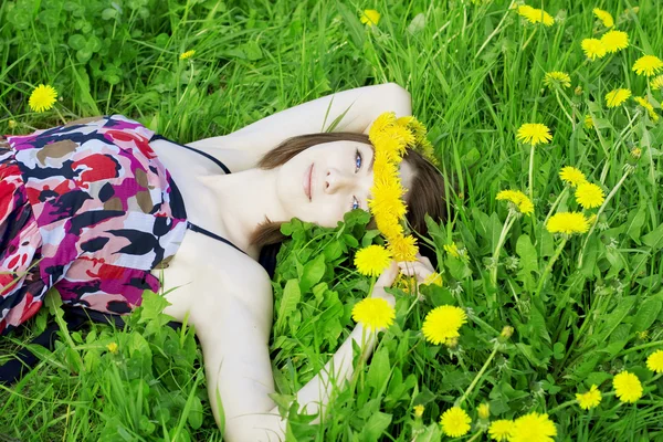 Dívka na pozadí kvetoucích květin — Stock fotografie