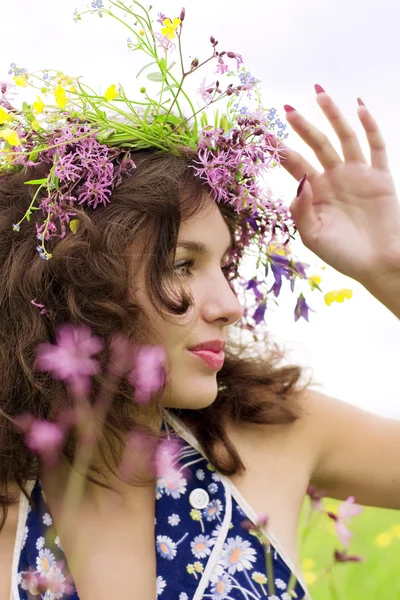 Menina vestindo uma coroa de flores selvagens no campo — Fotografia de Stock