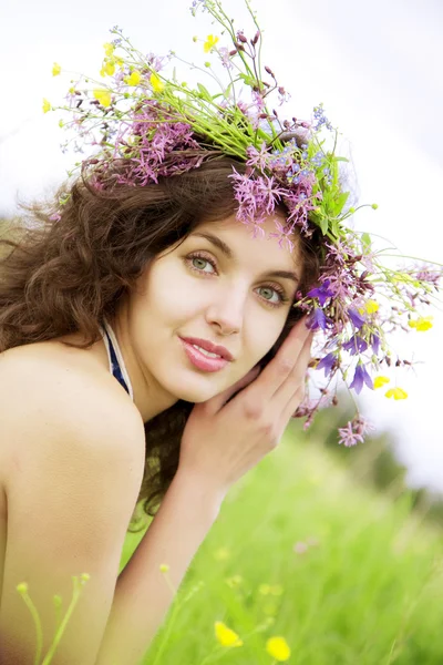 フィールドに野生の花の花輪を着ている少女 — ストック写真