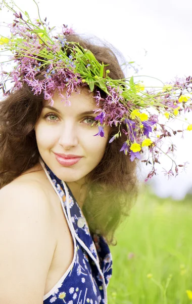 Girl wearing a wreath of wild flowers in the field — Stock Photo, Image