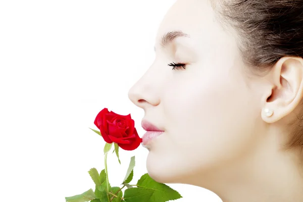 Krásná dívka tvář zblízka s růží v ruce — Stock fotografie