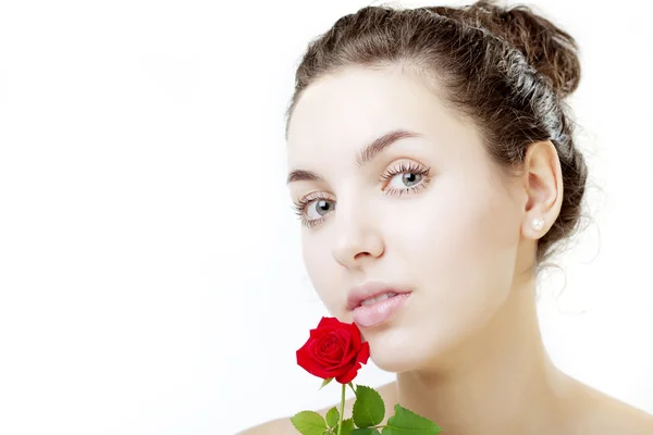 Mooi meisje gezicht close-up met een roos in de hand — Stockfoto
