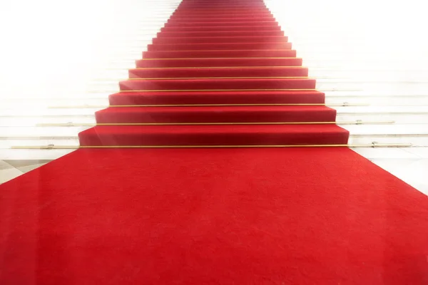 Лестница с красной ковровой дорожкой, освещенная светом — стоковое фото