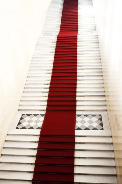 Schodiště s červený koberec, osvětlené světlem — Stock fotografie