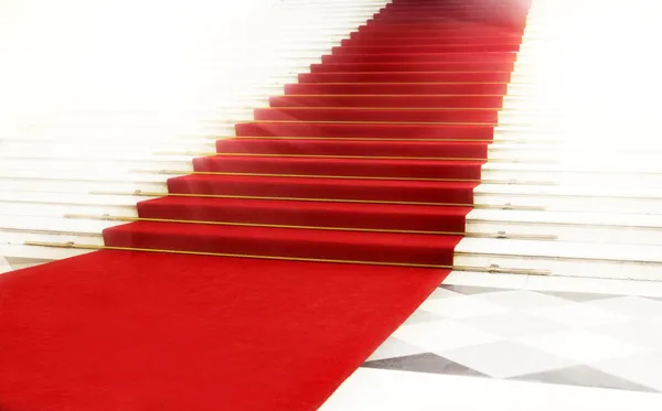 Лестница с красной ковровой дорожкой, освещенная светом — стоковое фото