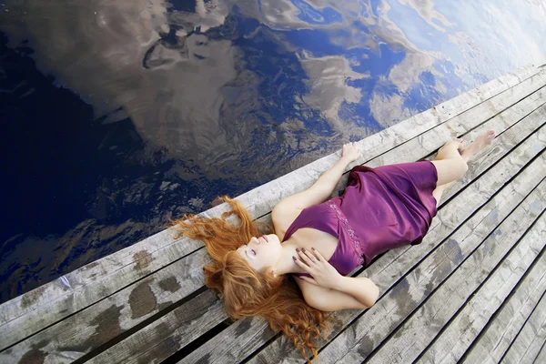 Iskeleye mor elbiseli güzel kızıl saçlı kız — Stok fotoğraf