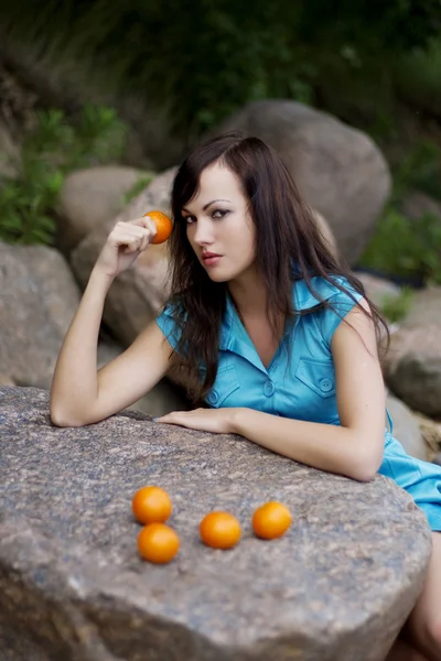 Piękna, młoda dziewczyna z mandarynek w przyrodzie — Zdjęcie stockowe