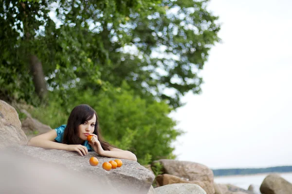 Beautiful young girl with the mandarins in nature — Stock Photo, Image