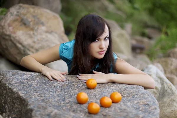 Vacker ung flicka med mandariner i naturen — Stock fotografie