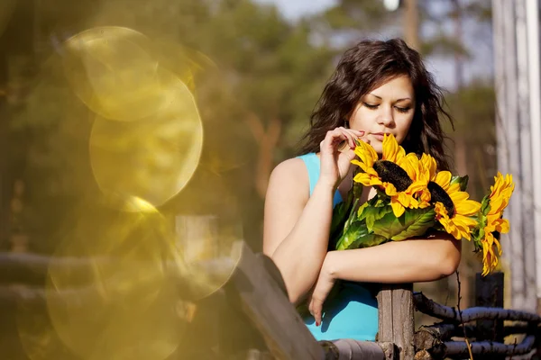 Meisje op het platteland met zonnebloemen — Stockfoto