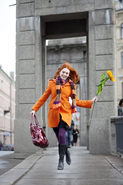 Mooi meisje lopen met een zonnebloem stad — Stockfoto